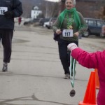 A pair of young volunteers helped hand out medals to all the runners and walkers at the finish line of Speare's Shamrock Shuffle 5K