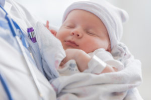Sweet infant sleeps in doctor's arms