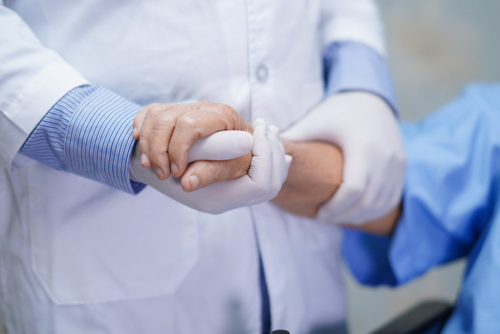 Doctor holding touching hands Asian senior or elderly old lady woman patient with love, care, helping, encourage and empathy at nursing hospital ward : healthy strong medical concept
